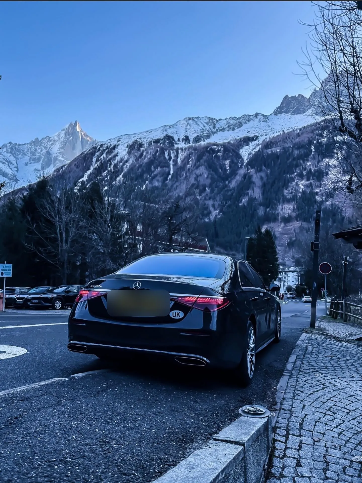 Mercedes S-Class parked on a mountain road in Chamonix with snowy Alps behind